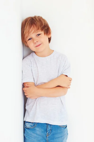 Beau jeune garçon, gosse posant près du mur blanc — Photo