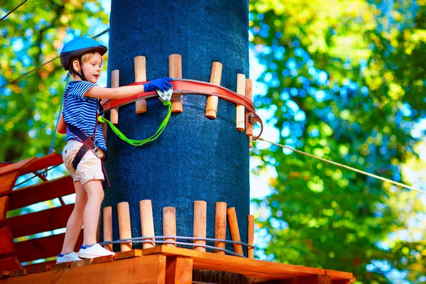 Młody chłopak przekazując trasy kabla wysokiej wśród drzew, sportów ekstremalnych w parku rozrywki — Zdjęcie stockowe