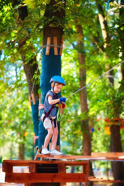 Młody chłopak przekazując trasy kabla wysokiej wśród drzew, sportów ekstremalnych w parku rozrywki — Zdjęcie stockowe