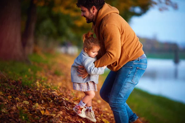 快乐的爸爸抱着一个小女孩 在秋天的公园里玩得开心 — 图库照片
