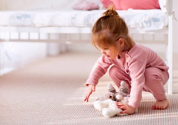 かわいい赤ちゃんが自宅の保育室でカーペットの上でおもちゃを遊んで — ストック写真