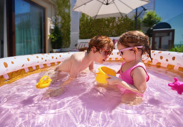 Opgewonden Kinderen Hebben Plezier Opblaasbaar Zwembad Thuis Patio Zonnige Zomerdag — Stockfoto