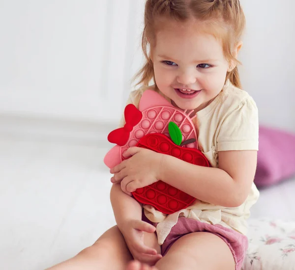 Fröhliches Kleines Mädchen Mit Bunten Sinnesspielzeugen Knallen Sie Zappeln Spielzeug — Stockfoto