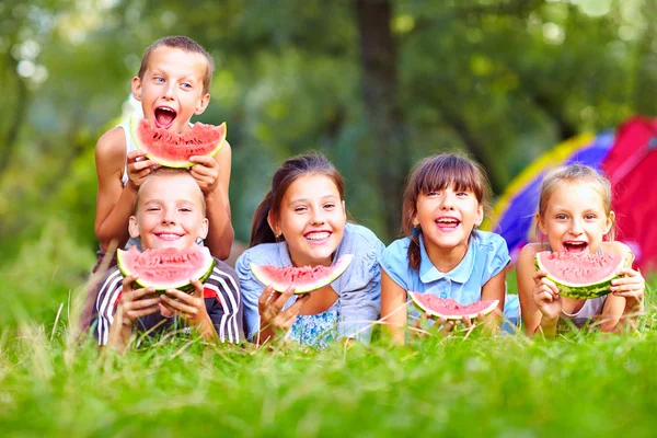Grupo de crianças felizes comendo melancias — Fotografia de Stock