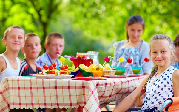 Happy kids around picnic table — Stock Photo, Image