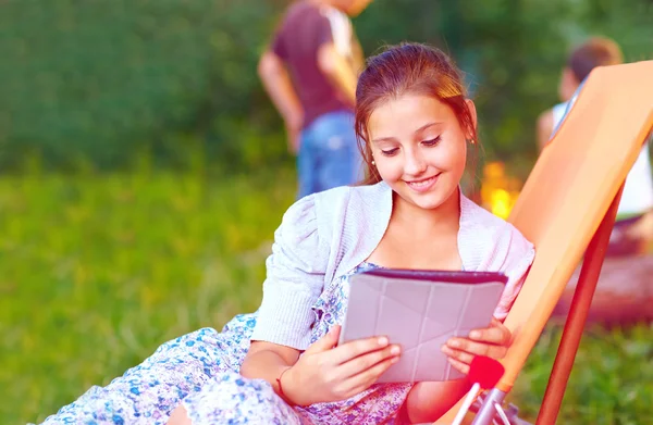 Vacker flicka med tablett på sommar picknick — Stockfoto