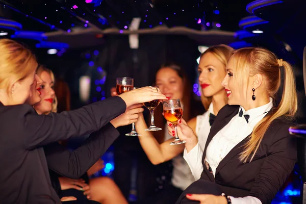 Beautiful women clinking glasses in limousine — Stock Photo, Image