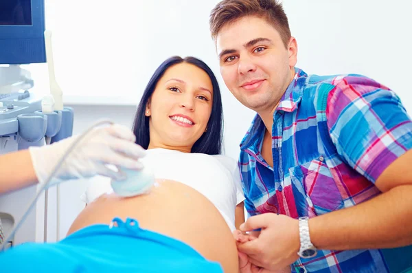 Happy pregnant couple on ultrasound diagnostic — Stock Photo, Image