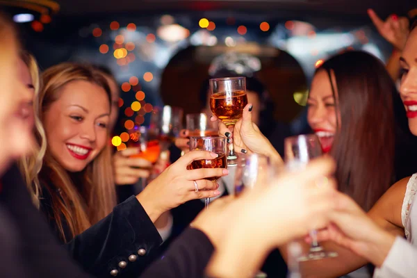 Schöne Frauen klirren mit Brille in Limousine — Stockfoto