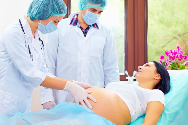 Doctor palpates the abdomen of pregnant woman before childbirth — Stock Photo, Image