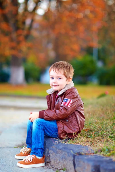 Улыбающийся мальчик в кожаной куртке и джинсах — стоковое фото