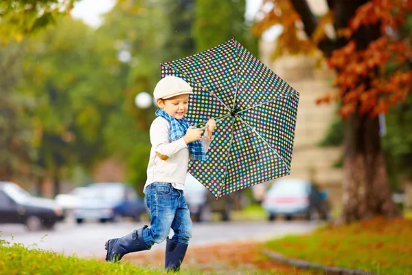 Happy stylish boy with umbrella running in park — Stock Photo, Image