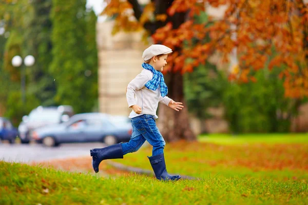 Menino elegante feliz com guarda-chuva correndo no parque — Fotografia de Stock