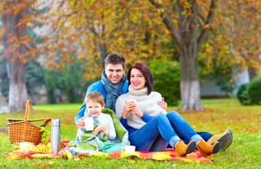 mutlu bir aile sonbahar pikniğe sıcak çay içme