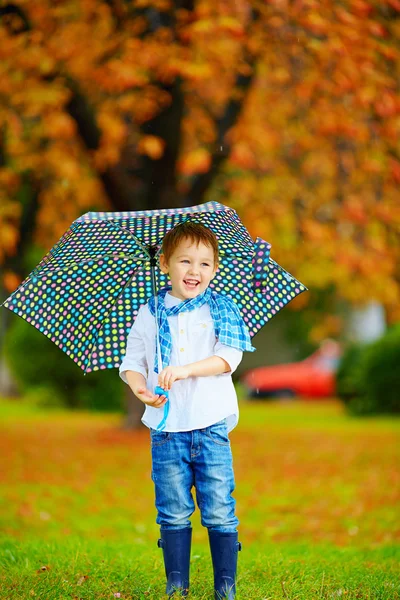 Joyeux garçon marchant sous une pluie d'automne — Photo