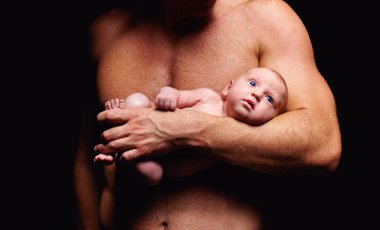 tiny newborn baby in strong father's hand clipart