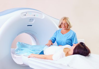 mid adult medical staff preparing patient to tomography clipart