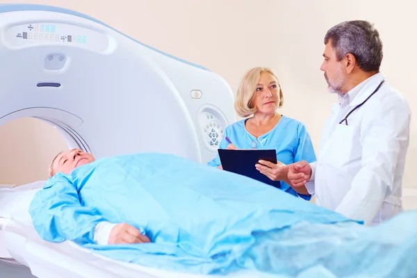 Médico instruindo a equipe médica sobre o procedimento CT scanner — Fotografia de Stock