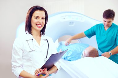Portrait of beautiful doctor in CT scanner room clipart