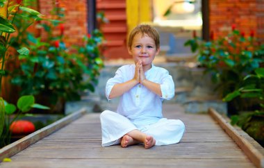 cute boy trying to find inner balance in meditation clipart