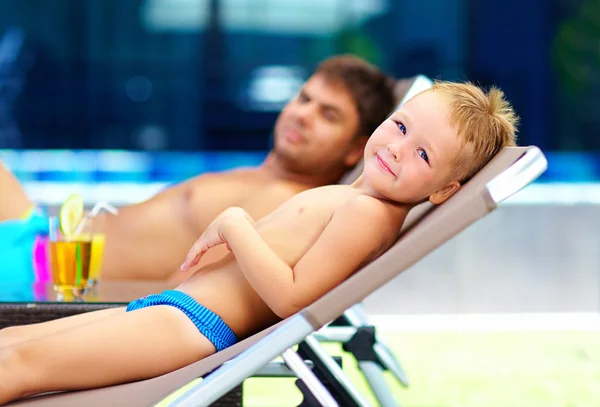 Feliz familia tomando el sol cerca de la piscina — Foto de Stock