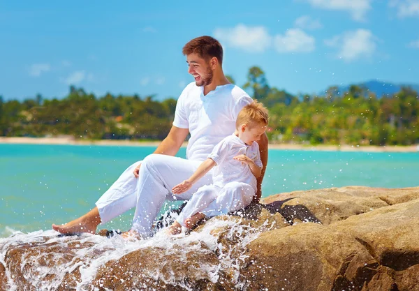 Éclaboussures d'eau sur heureux père et fils en vacances — Photo