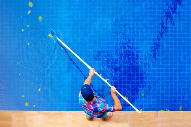 young adult man, personnel cleaning the pool from leaves clipart