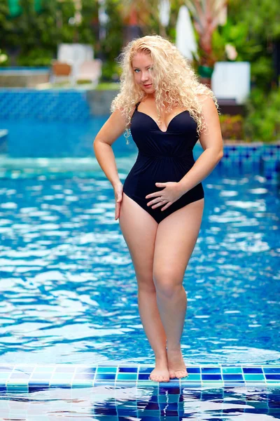 Schöne Plus-Size-Frau posiert im Pool — Stockfoto