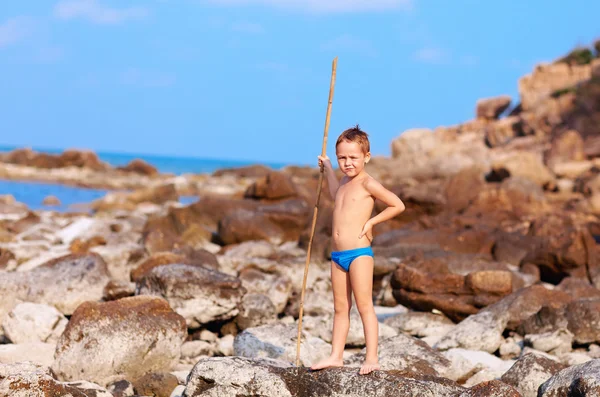 Χαριτωμένο αγόρι με μπαμπού δόρυ προσποιείται ότι σαν να είναι αυτόχθων σε έρημο νησί — Φωτογραφία Αρχείου