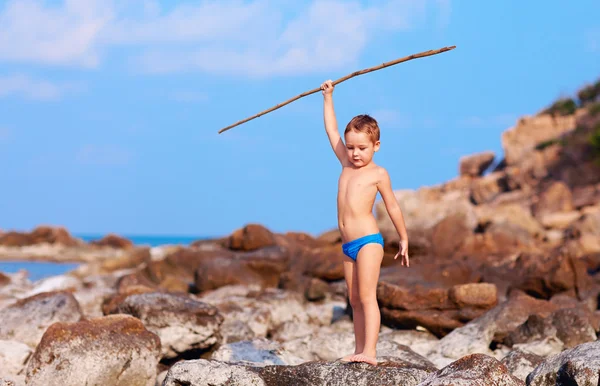 Χαριτωμένο αγόρι με μπαμπού δόρυ προσποιείται ότι σαν να είναι αυτόχθων σε έρημο νησί — Φωτογραφία Αρχείου