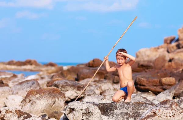 Carino ragazzo con bambù lancia finge come egli è aborigeno su isola deserta — Foto Stock