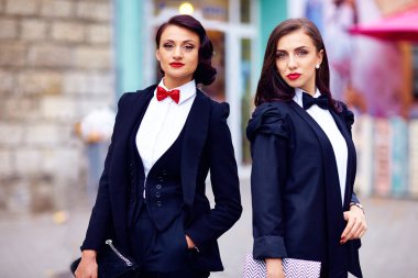 Siyah takım elbiseli poz iki güzel kadın