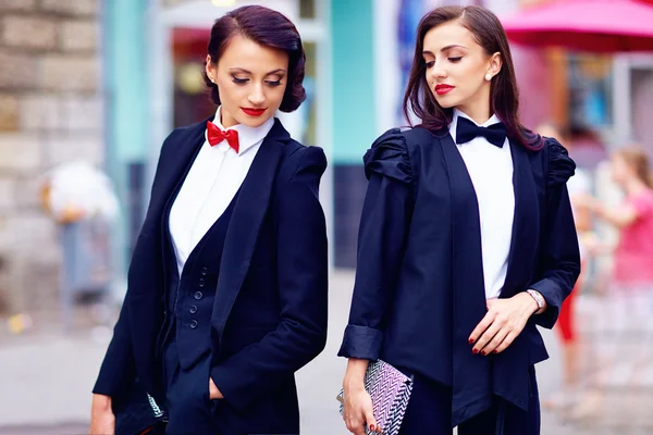 Dos hermosas mujeres posando en trajes negros — Foto de Stock