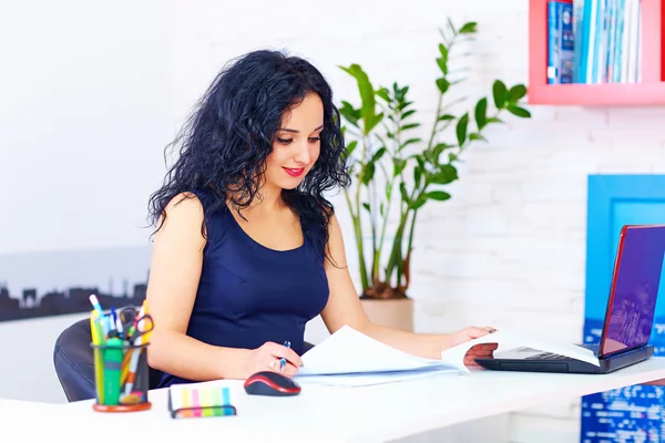 Femme souriante travaillant dans le bureau — Photo