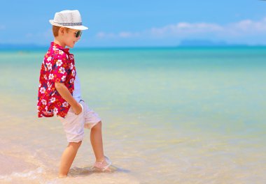 sevimli çocuk, yaz sahilde dalgalar içinde oynayan çocuk