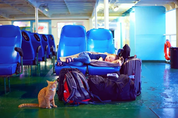 Хлопчик спить на сидіннях під час виснажливої подорожі на поромному човні — стокове фото
