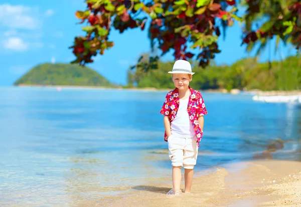 Bonito garoto menino andando na água na praia tropical — Fotografia de Stock