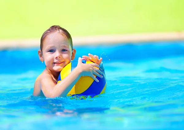 Garoto bonito jogando jogos de esporte de água na piscina — Fotografia de Stock