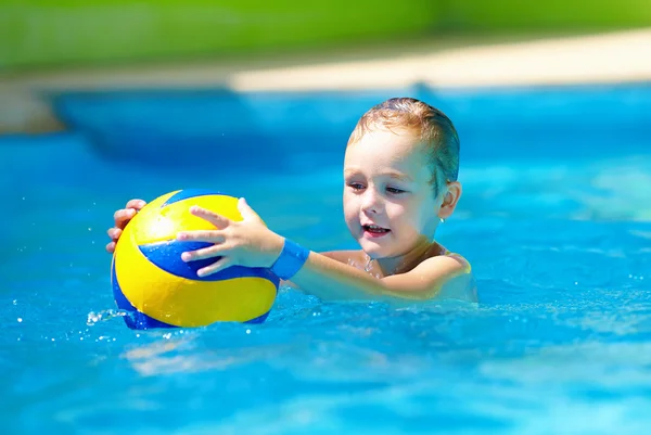 Garoto bonito jogando jogos de esporte de água na piscina — Fotografia de Stock