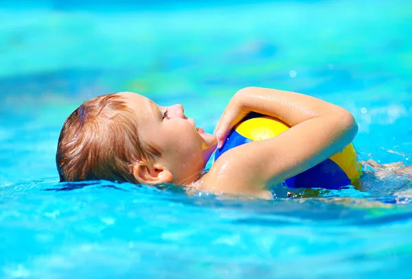 Garoto bonito jogando jogos de esporte de água na piscina — Fotografia de Stock