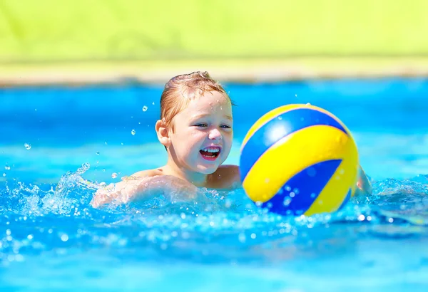 Garoto bonito jogando na água jogos de esporte na piscina — Fotografia de Stock