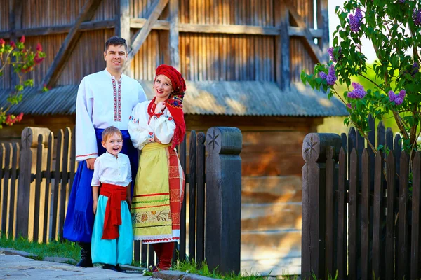 Портрет украинской семьи, одетой в традиционные костюмы возле дома — стоковое фото