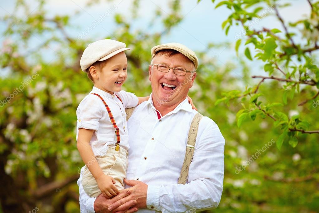happy grandfather and grandson having fun in spring garden