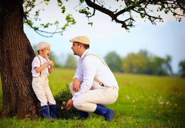 Çiftçi aile eğleniyor yaşlı bir ağaç bahar kırsal altında