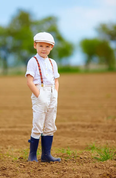 Portrait of cute farmer boy on spring field — Stock Photo, Image