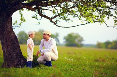 Çiftçi aile eğleniyor yaşlı bir ağaç bahar kırsal altında
