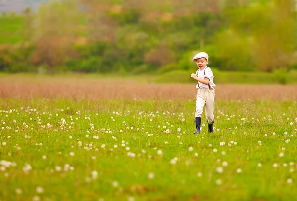 Animado bonito menino correndo florescendo campo, primavera campo — Fotografia de Stock