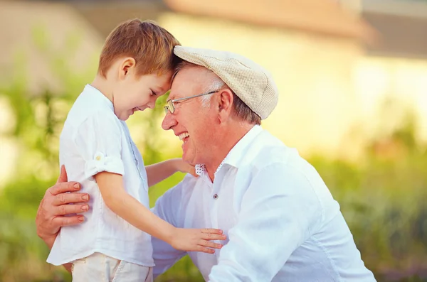 Portrait of happy grandfather and grandson bow their heads — Stock Photo, Image