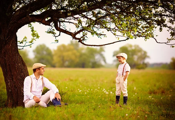 Famiglia contadina divertirsi sotto un vecchio albero, campagna primaverile — Foto Stock