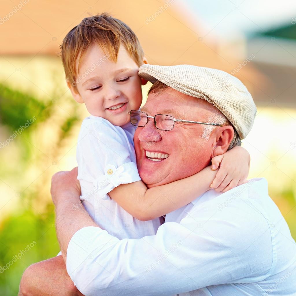 Portrait of happy grandpa and grandson embracing outdoors Stock Photo Portrait of happy grandpa and grandson embracing outdoors Stock Photo